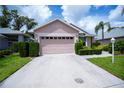 Home featuring a well-kept lawn, pruned hedges, and a two-car garage at 519 Catalina Isles Cir, Venice, FL 34292