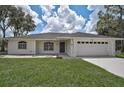 A charming one-story home with a well-maintained lawn, a two-car garage, and a concrete driveway at 5306 Maccaughey Dr, North Port, FL 34287