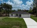 A charming one-story home with a well-maintained lawn, a two-car garage, and a concrete driveway at 5306 Maccaughey Dr, North Port, FL 34287