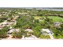 Aerial view of the home showcases its location in a verdant, tree-filled neighborhood near a green sports field at 5369 Shadow Lawn Dr, Sarasota, FL 34242