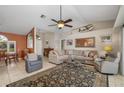 Bright living room features a vaulted ceiling, comfortable seating, and an eye-catching rug on tile flooring at 5818 Harrison Rd, Venice, FL 34293