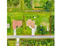 Aerial view of a property with spacious green lawns, an adjacent house, and a clearly outlined property line at 5954 Gottfried Ln, North Port, FL 34291