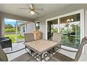 Cozy screened patio with comfortable seating, a ceiling fan, and sliding glass doors leading to the home's interior at 5954 Gottfried Ln, North Port, FL 34291