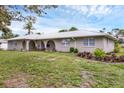 Eye-level exterior view showcasing well-landscaped grounds, charming architecture, and a metal roof at 612 Bayshore Rd, Nokomis, FL 34275