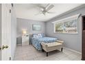 Cozy bedroom with a ceiling fan, window, and blue bedding at 614 Guild Dr # 10, Venice, FL 34285