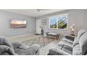 Comfortable living room with large windows, gray furnishings, and tile flooring at 614 Guild Dr # 10, Venice, FL 34285