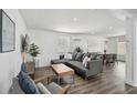 Bright living room with modern gray sofa, hardwood floors, and stylish decor at 616 S Casey Key Rd, Nokomis, FL 34275