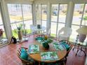 The well-lit screened porch offers scenic views and a relaxed atmosphere with a dining set at 623 Leisure, Venice, FL 34285