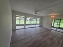 Bright living room featuring wood flooring, a ceiling fan, and large glass windows overlooking the backyard at 624 White Pine Tree Rd # 5, Venice, FL 34285