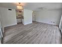 A wide shot of the living room showing the open concept to the kitchen and the bright, new floors at 624 White Pine Tree Rd # 5, Venice, FL 34285