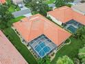 Aerial view of a single-Gathering home featuring a red tile roof, screened-in pool, and well-maintained landscaping at 6619 Pinefeather Ct, Bradenton, FL 34203
