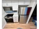 Compact kitchen with stainless steel appliances and modern white cabinets at 7201 Daiquiri Ln, Tampa, FL 33634