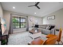 Cozy living room features plush seating, large window, ceiling fan, and neutral decor at 7257 Maguire Ln, Englewood, FL 34224