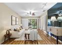 Bright living room with wood floors, fan, track lights and access to the enclosed porch at 756 White Pine Tree Rd # 204, Venice, FL 34285