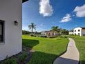Well maintained walkway with a pool and lush landscaping in the community at 800 Capri Isles Blvd # 235, Venice, FL 34292