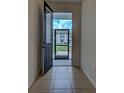 Bright entryway with tile floors and a view through a screened doorway to the outdoors at 9157 Genesee St, Port Charlotte, FL 33981