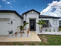 Front entrance with a rock garden, walkway, and a black-framed glass door for a modern touch at 9157 Genesee St, Port Charlotte, FL 33981
