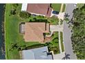 Aerial view of a private home with screened porch, lush backyard, and mature trees at 9528 Knightsbridge Cir, Sarasota, FL 34238