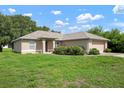 Charming single-story home featuring a well-maintained lawn, mature landscaping, and an attached two-car garage at 2397 Morton Rd, North Port, FL 34291