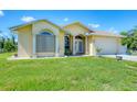 Inviting yellow home showcasing a well-manicured lawn and attached two-car garage at 102 Bayamo Dr, North Port, FL 34287