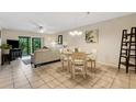 Open-concept living and dining area with a neutral color palette, tile flooring, and sliding doors to outdoor patio at 1100 Capri Isles Blvd # 215, Venice, FL 34292