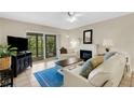 Bright living room featuring a cozy fireplace, comfortable seating, and sliding glass doors offering a view of the outdoors at 1100 Capri Isles Blvd # 215, Venice, FL 34292