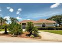 A single-story home with desert-style landscaping and a red tile roof under a blue sky with white clouds at 1136 Deardon Dr, Venice, FL 34292