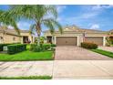 Welcoming home boasting lush landscaping, a brick driveway, and a two-car garage at 11739 Okaloosa Dr, Venice, FL 34293
