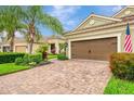 Exterior view of a home featuring a brick driveway and lush landscaping at 11739 Okaloosa Dr, Venice, FL 34293