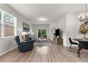 Open-concept living room with a chandelier, wood floors, ample seating, and access to the backyard at 11819 Tempest Harbor Loop, Venice, FL 34292