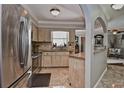 Well-lit kitchen featuring stainless steel appliances, tile flooring and backsplash, and an open layout to the living area at 1198 Jamaica Rd, Venice, FL 34293