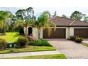 Charming home featuring a brick driveway, beautiful landscaping, and a tiled roof at 12187 Amica Loop, Venice, FL 34293