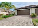 Garage featuring lush landscaping and a well-maintained driveway at 12187 Amica Loop, Venice, FL 34293