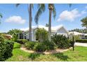 Landscaped lawn with palms and low shrubbery complement this single-story home's neutral palette at 1234 Harbor Town Way, Venice, FL 34292