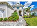 Inviting front entry with stone walkway, lush landscaping, and a charming portico with blue accents at 12404 Destin Loop, Venice, FL 34293