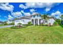Well-manicured lawn with professional landscaping and a paver walkway leading to this home with a three-car garage at 12404 Destin Loop, Venice, FL 34293