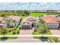 An aerial view shows the house, beautiful landscaping, and surrounding community at 13092 Rinella St, Venice, FL 34293