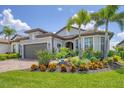 Beautiful single-story home with lush landscaping, a brick driveway, and a two-car garage at 13092 Rinella St, Venice, FL 34293