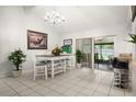 Bright dining room with tile flooring, chandelier, white table, and sliding glass doors at 13608 Westshire Dr, Tampa, FL 33618