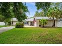 Charming single Gathering home with a well maintained lawn, mature trees and American flag at 13608 Westshire Dr, Tampa, FL 33618