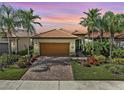 Charming single-Gathering home featuring a tile roof, lush landscaping, and a paver driveway at 13841 Campoleone St, Venice, FL 34293