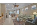Cozy living room with neutral walls, tile flooring, a ceiling fan, and a view into the dining area at 13841 Campoleone St, Venice, FL 34293