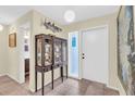 Inviting entryway with tile flooring, decorative display case, and a brightly lit front door, creating a warm welcome at 16 Oakwood N Dr # 16, Englewood, FL 34223