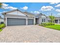 Charming single-story home featuring a three-car garage, lush landscaping, and a welcoming entrance at 1607 Laurel Brook Ln, Port Charlotte, FL 33953