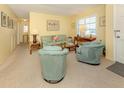 Inviting living room featuring a seating arrangement, neutral carpet, and bright natural light at 168 The Corso # 168, Venice, FL 34285