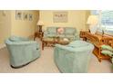 Comfortable living room with neutral carpet, matching furniture, and a charming tropical aesthetic at 168 The Corso # 168, Venice, FL 34285