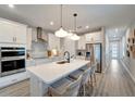 Modern kitchen featuring an island with seating, stainless steel appliances, and pendant lighting at 17873 Grand Prosperity Dr, Venice, FL 34293