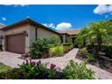 Beautiful single-story home featuring a well-manicured front yard with lush landscaping and a brick pathway at 19269 Serafina St, Venice, FL 34293