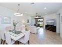 Bright open-concept living space with tile floors, modern lighting, and sliding doors to outdoor living area at 19269 Serafina St, Venice, FL 34293