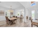 Bright dining room boasts an open floor plan with wood flooring and elegant lighting fixtures at 2146 Snapdragon Ln, Venice, FL 34292